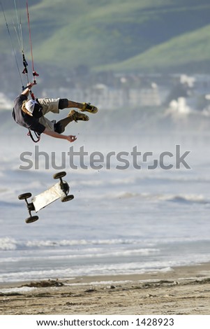 A kite skateboarder, or landboarder, catches extreme air on the California coast.
