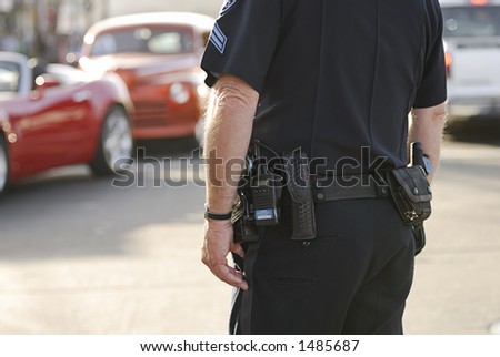 A traffic cops watches a busy intersection.
