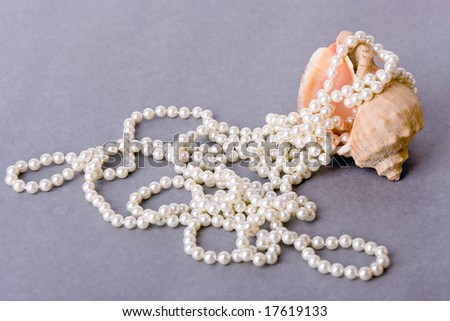 a photo of pink shell with white pearl beads