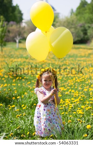 little girl with yellow balloons on dandelion field