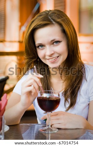 a pretty girl in cafe drinking red juice
