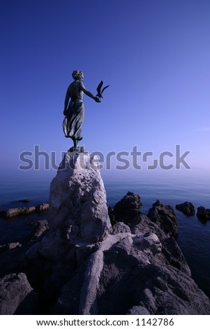 Woman sculpture with sea gull by the sea rocks in Opatija Croatia