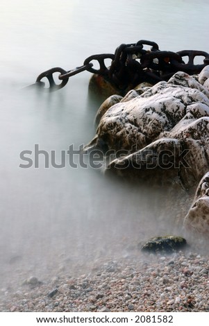 Rocks and ship chain in the sea water with long exposition