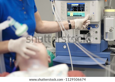 An anesthesiologist monitors the condition of a patient under general anesthesia