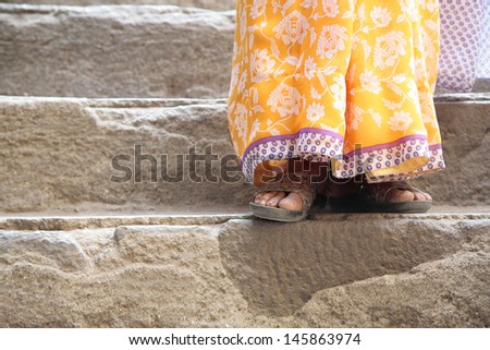 Indian woman standing on a stairs, feet closeup