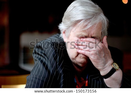 Elderly woman cover her face with hand