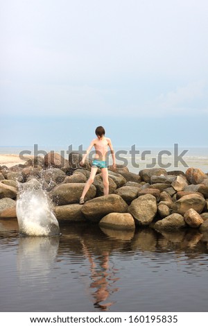 Boy throwing rock in the water