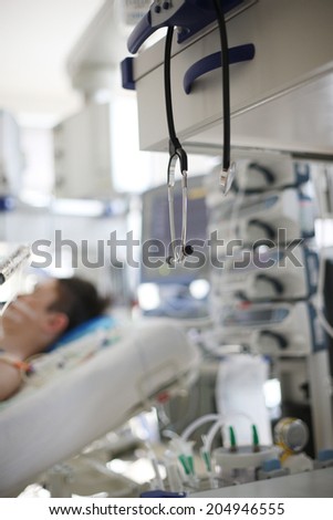 Medical equipment in hospital with background of patient sleeping in bed