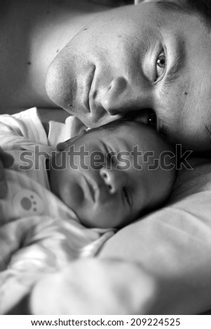 Portrait of happy daddy and his sleepy child; monochrome