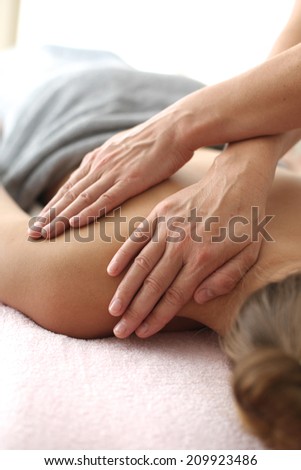 Woman\'s shoulder massage; hands of masseur