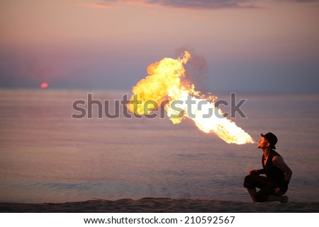 Amazing fire-breathing on the beach at sunset