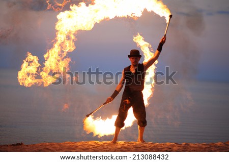 Fire dancer twirling fire torch; impressive open air performance