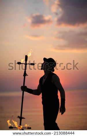 Man profile with a fire torch on sunset background