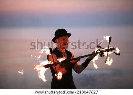 Smiling man juggling with fire torch