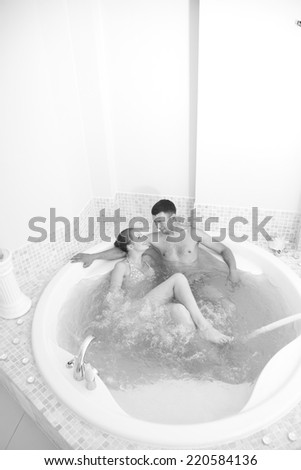 Modern spa salon with loving couple in jacuzzi;monochrome