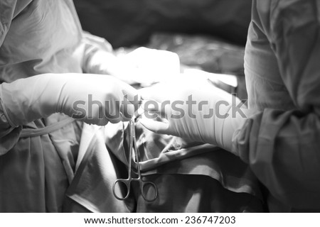 Team of surgeons performing operation; mid section