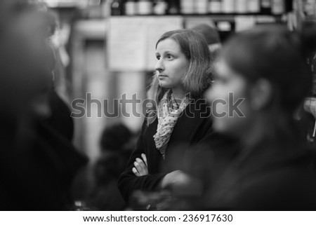 Young beautiful woman in the crowd indoors, monochrome