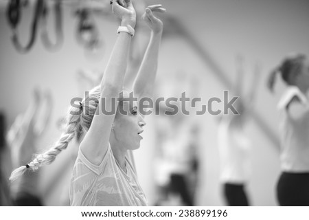 Close up profile of young woman lifted arms, group fitness concept, monochrome