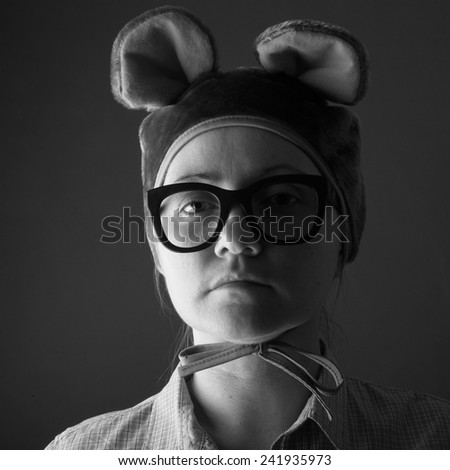 Portrait of a serious woman wearing funny animal hat and eyeglasses, monochrome