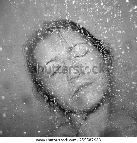 Face of young beautiful woman covered with water drops