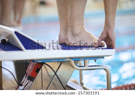 Feet of a swimmer on diving platform