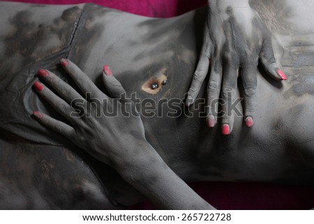 Mid section of a woman in mud having spa procedure