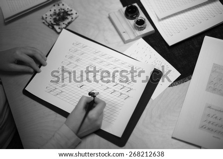 Beginner writing a calligraphy alphabet