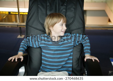 Cheerful boy sitting in the chair like a boss