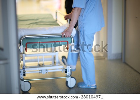 Health care worker pushing hospital mobile bed