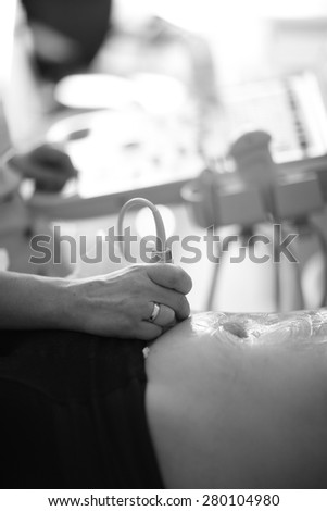 Doctor examining a patient\'s belly using ultrasound technique