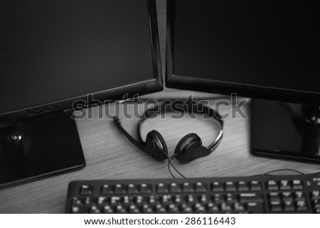 Headphones lying on the table next to a desktop computer