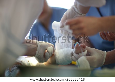 Doctors bandaging a wound on baby leg