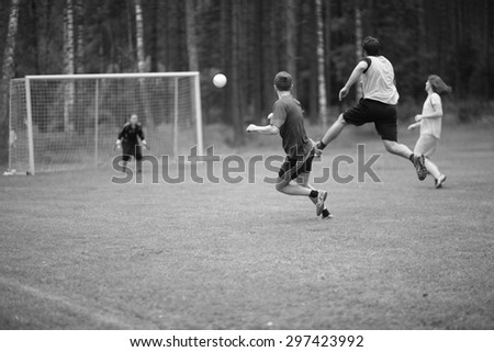 Guys playing football, players running towards the ball