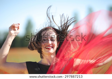 Excited face of a jumping woman with flying hair and skirt