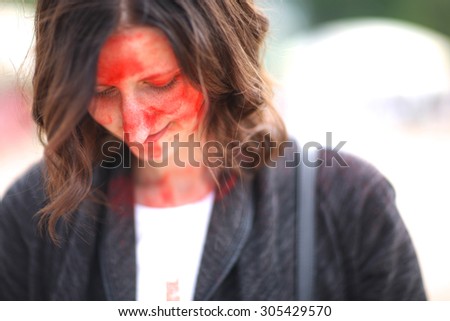 Shy smiling woman with painted face looking down