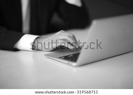 Details of businessman in formal suit using a laptop in office