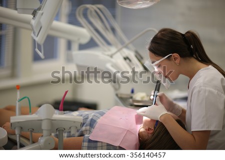 General dental practice, profile of a young female dentist at work