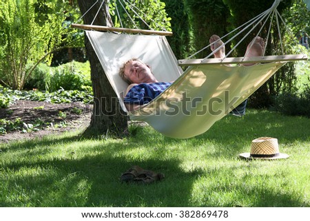Man relaxing in a hammock in a summer garden