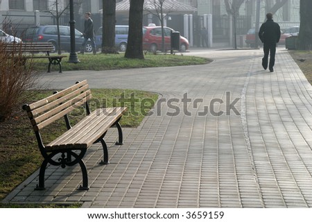 bench on the sine of a pathway in the city