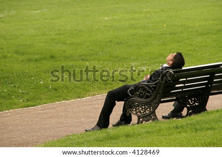 business man sleeping on park bench