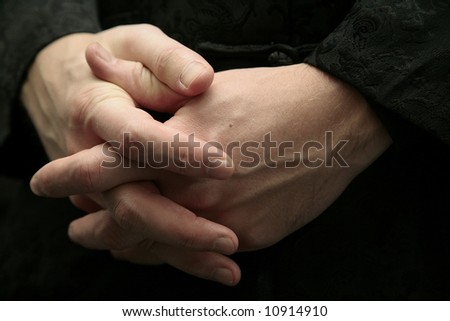 crossed hands of man on black background
