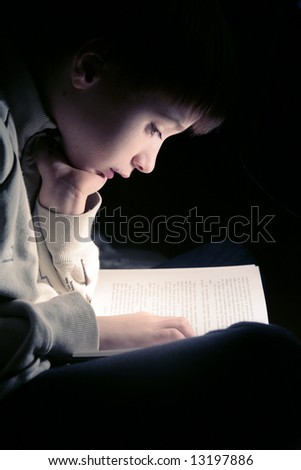 boy reading book, dark photo, key light coming from book