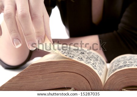 French manicured hand flipping through pages of book
