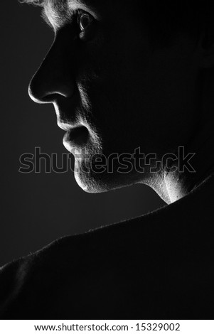stock photo Lowkey male portrait on black background