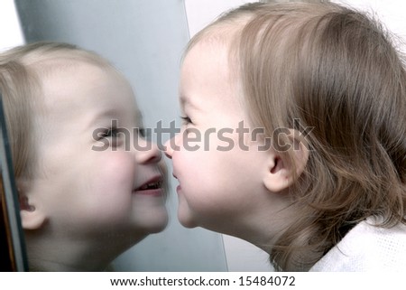 Cute baby looking into mirror, laughing