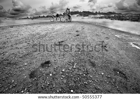 Romantic couple with bike in the beach in black and white