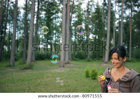 Smiling woman making soap bubbles