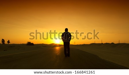Man walking on the road with relax mood. Desert road in Dubai, UAE