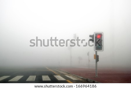 Fog in Dubai road. Red signal is on.