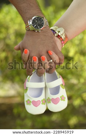 Concept Pregnant. Parents holding baby shoes in their hands. Mom and Dad Expecting a baby. New life